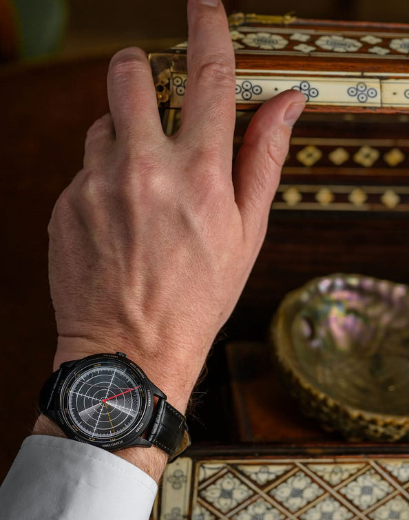 montre pearl 1941 avec eau encapsulee portee par un homme en chemise tenant un livre hommage a la seconde guerre mondiale