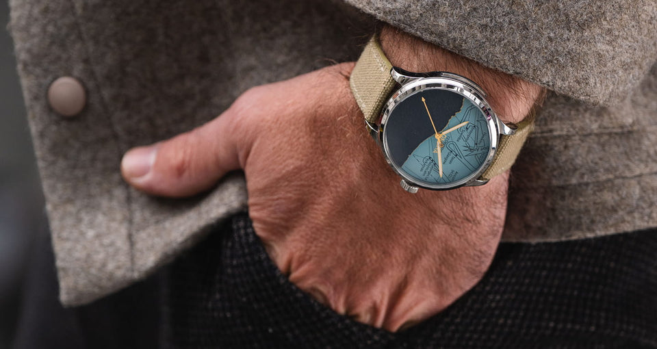 homme portant une montre dday avec mouvement suisse au poignet avec une veste grise
