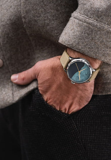 homme portant une montre dday avec mouvement suisse au poignet avec une veste grise