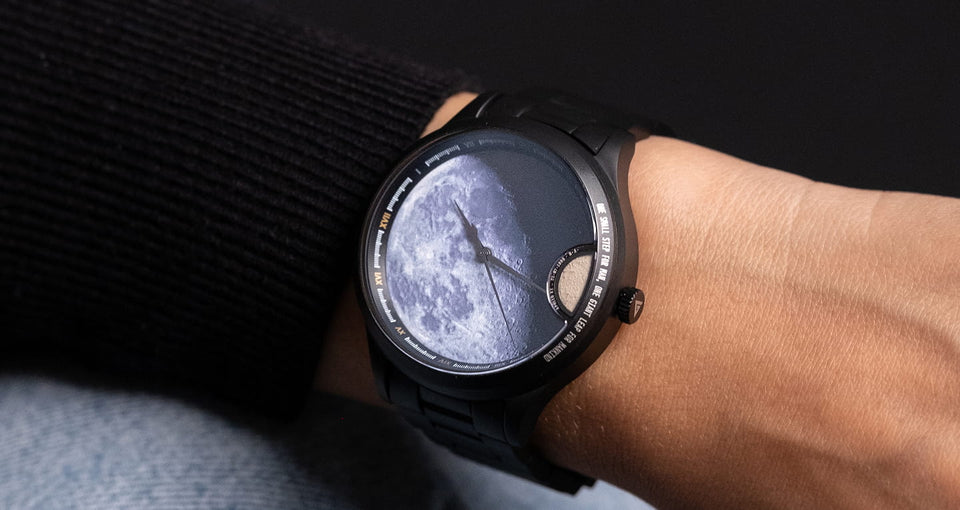 femme portant une montre automatique avec poussiere de meteorite lunaire au poignet avec un pull noir