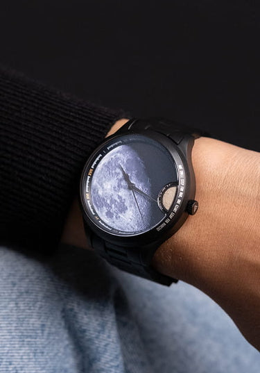 femme portant une montre automatique avec poussiere de meteorite lunaire au poignet avec un pull noir