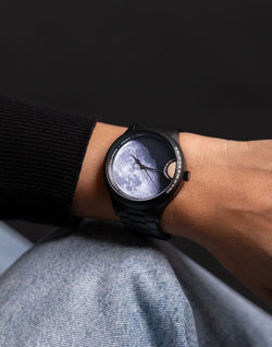 femme portant une montre avec poussiere de meteorite lunaire au poignet avec un pull noir inspiree de l exploration spatiale
